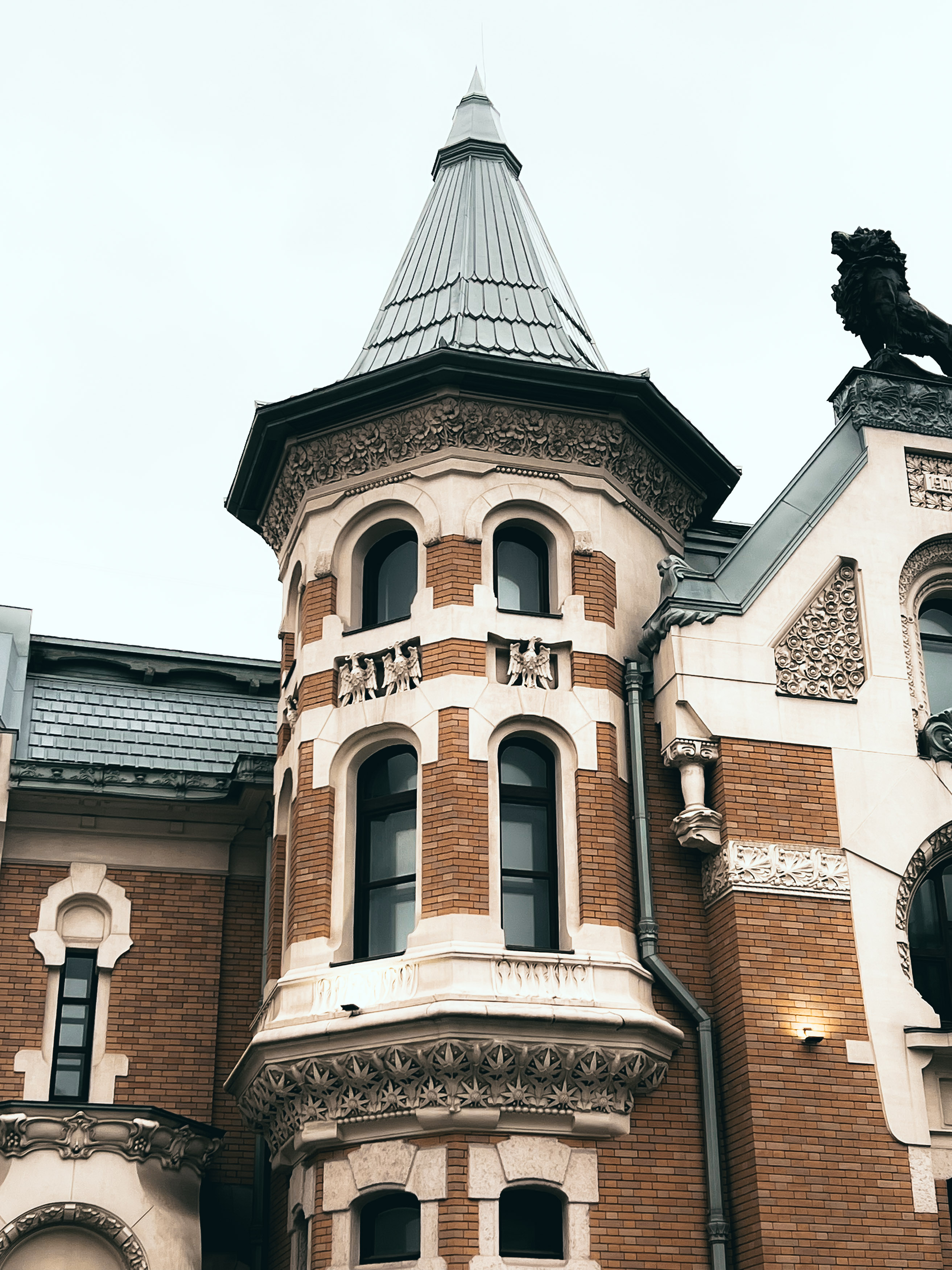 Гранёная башня и сочетание кирпичных и светлых участков фасада