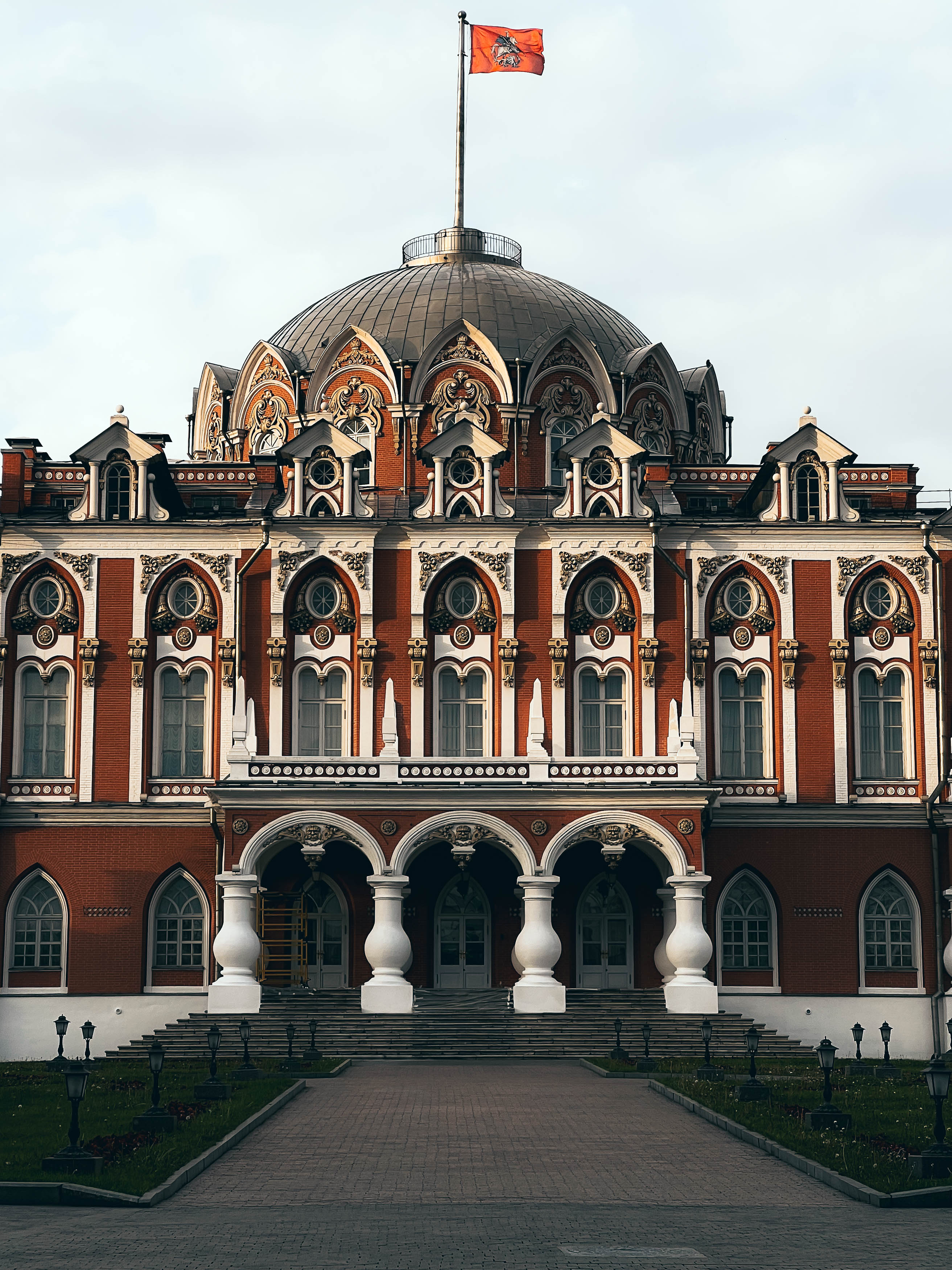 Главный корпус Петровского путевого дворца с белым декором на красном фасаде